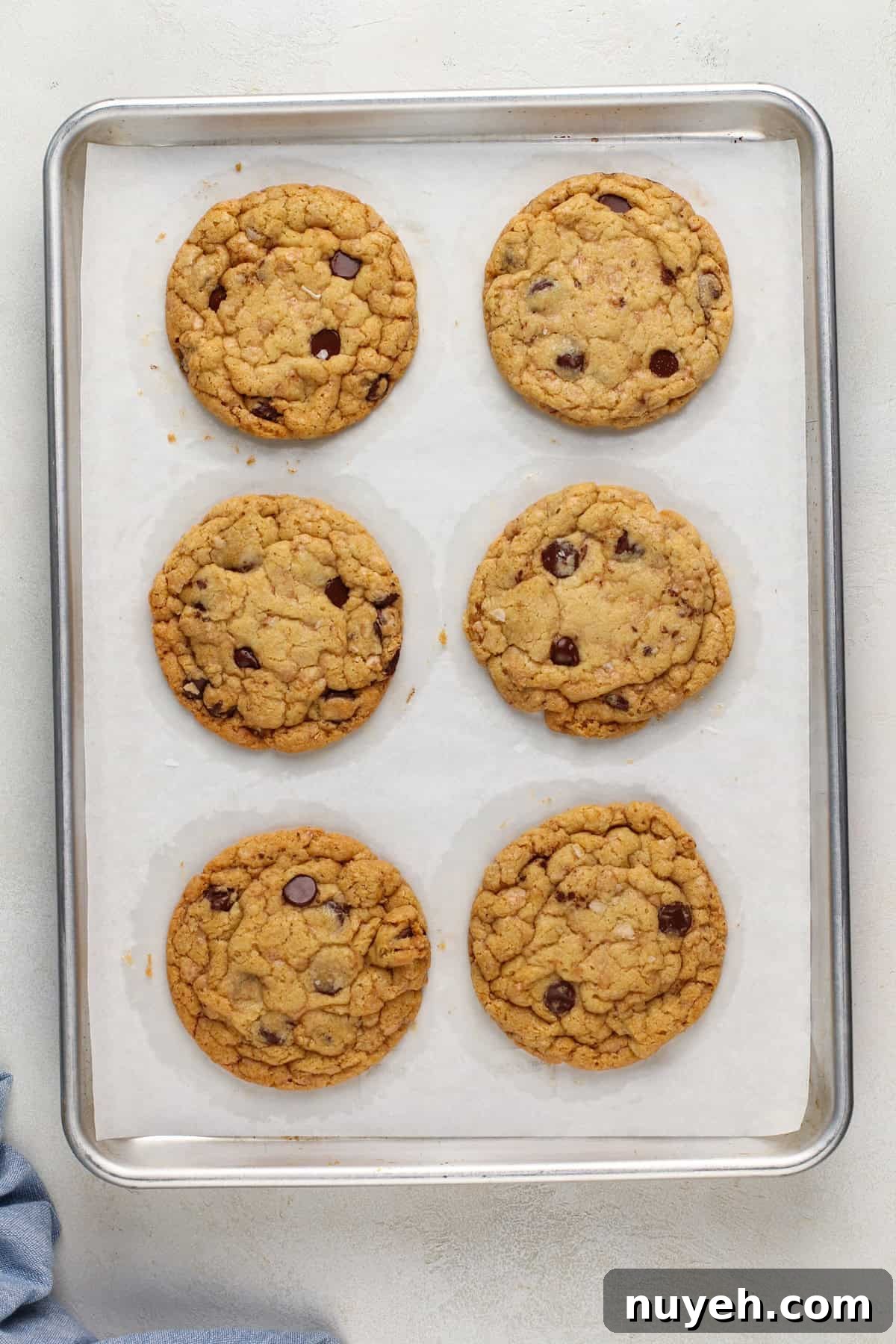 Freshly baked heath bar cookies on a lined sheet pan.