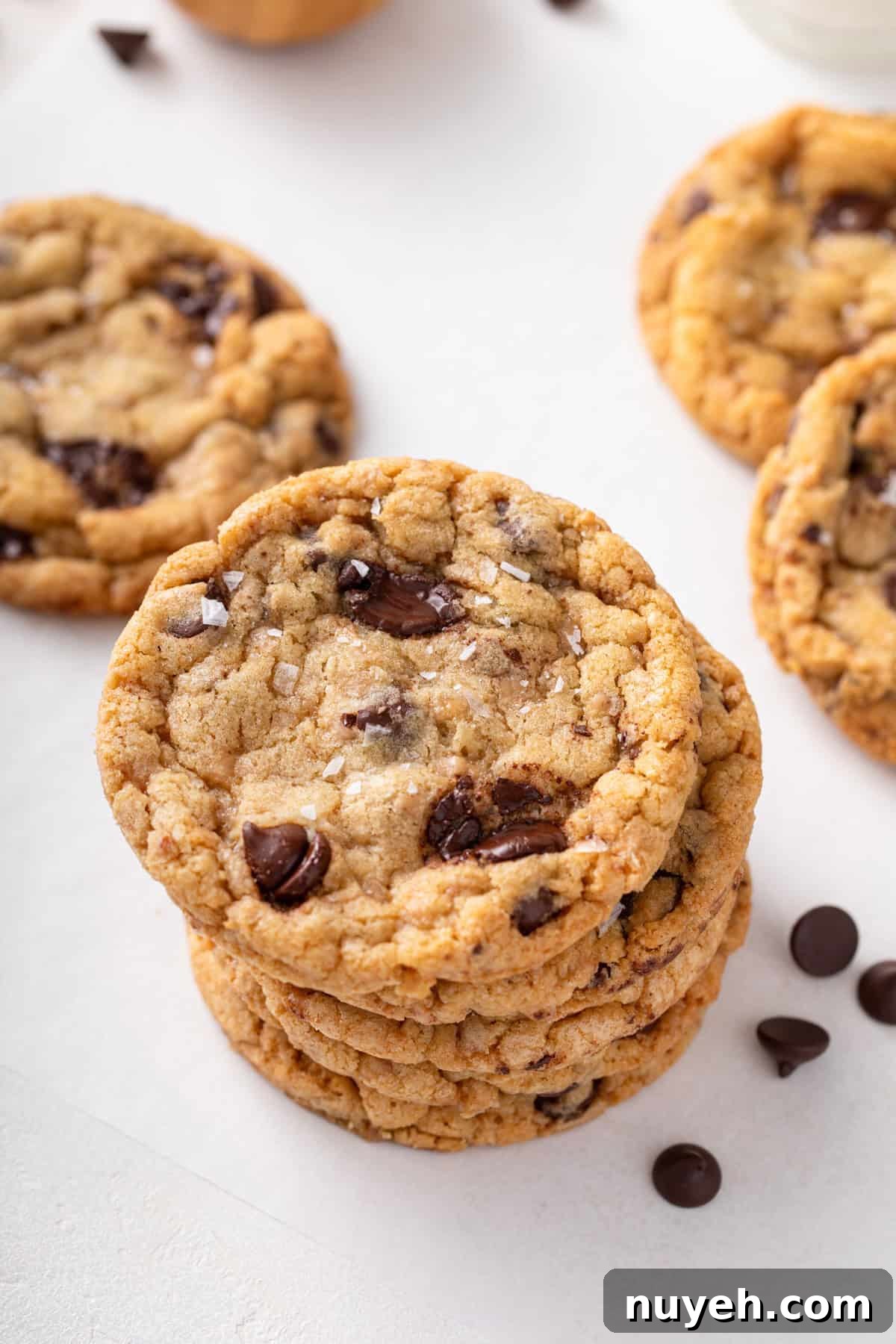 Several heath bar cookies stacked on a countertop.