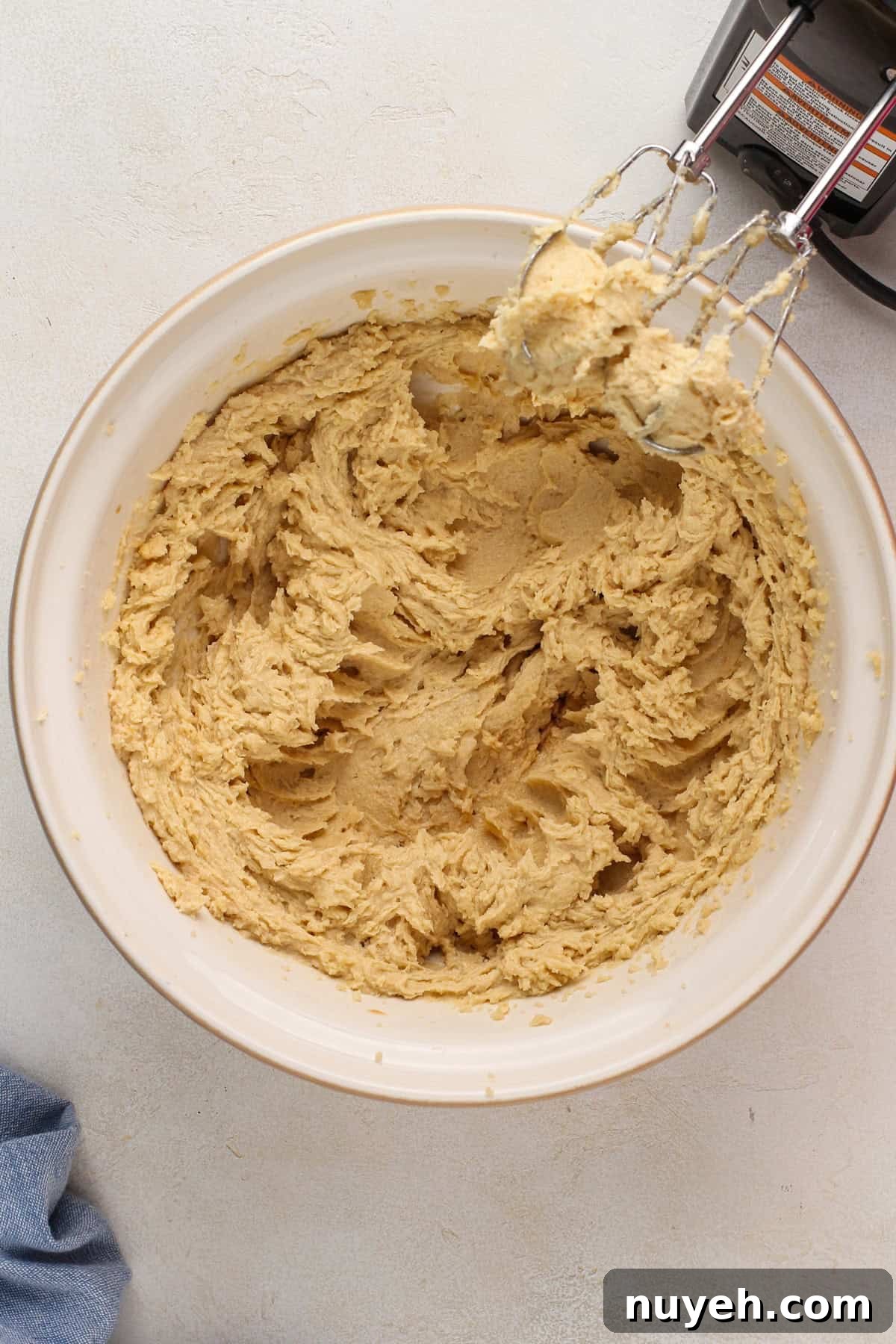 Wet ingredients for heath bar cookies mixed in a ceramic mixing bowl.