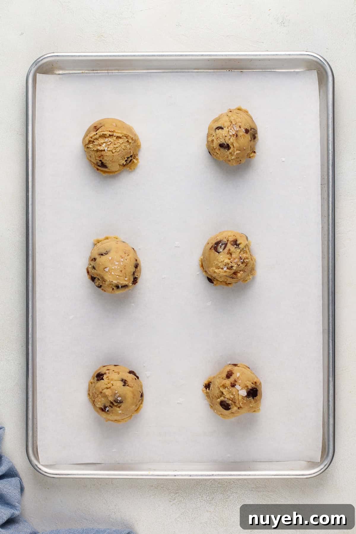 Portioned heath bar cookie dough on a sheet pan, ready to be baked.