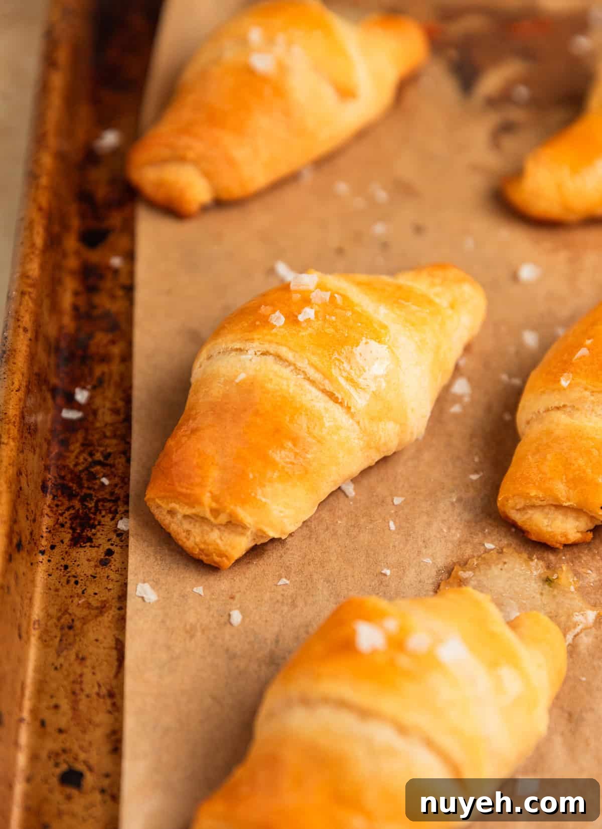 Butter topped crescent rolls on pan.