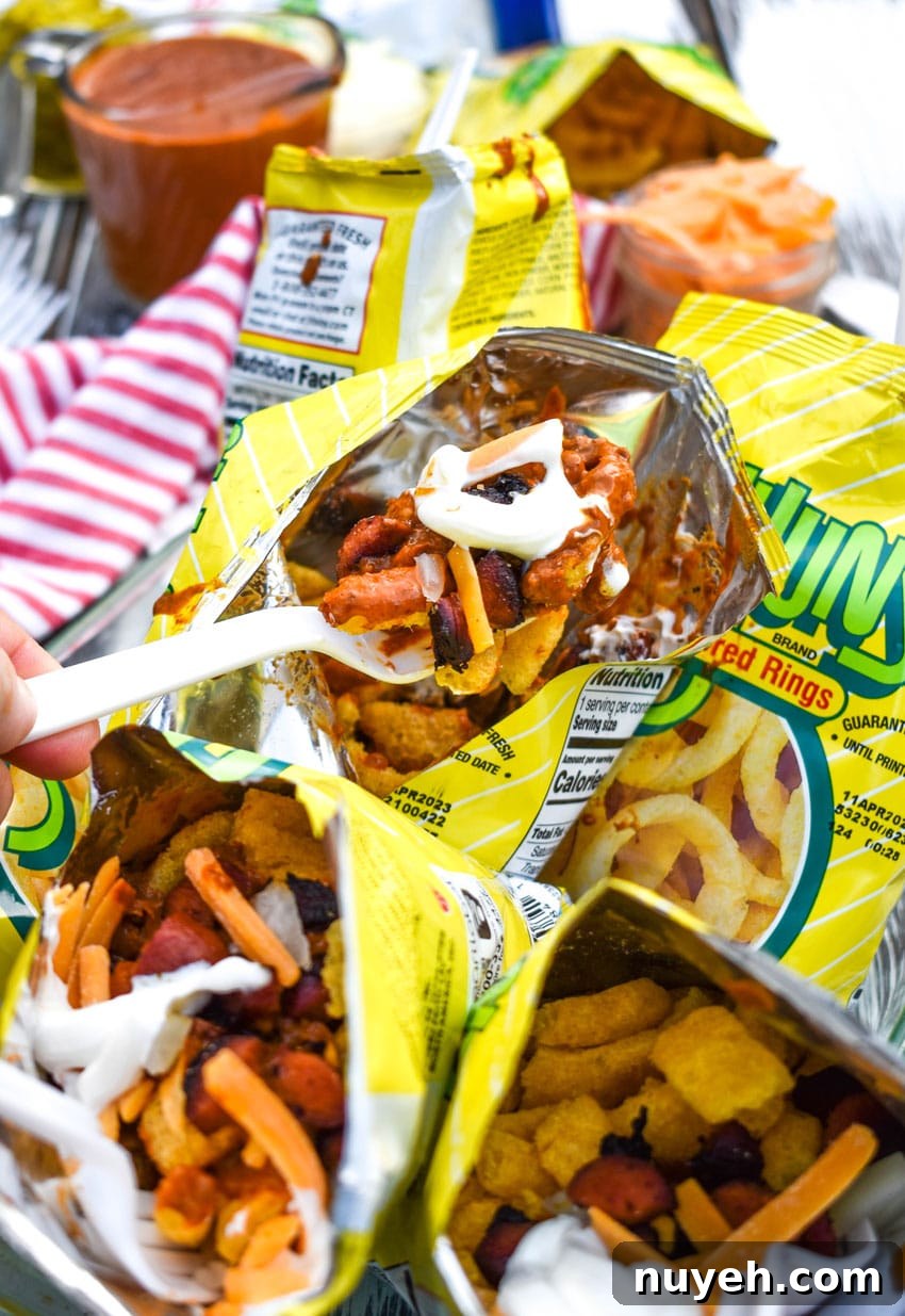 a plastic fork lifting a scoop of walking chili cheese dog out of a funyon bag