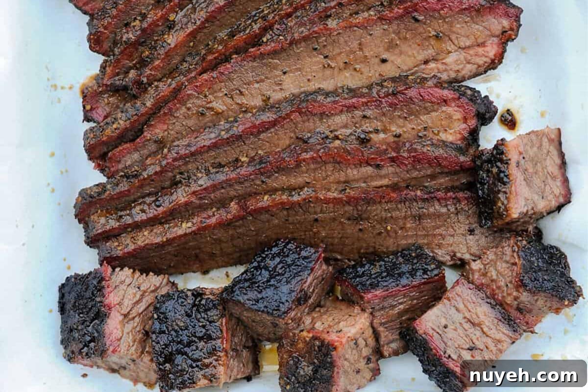 A closeup shot of sliced brisket and chopped brisket ends on a light plate.