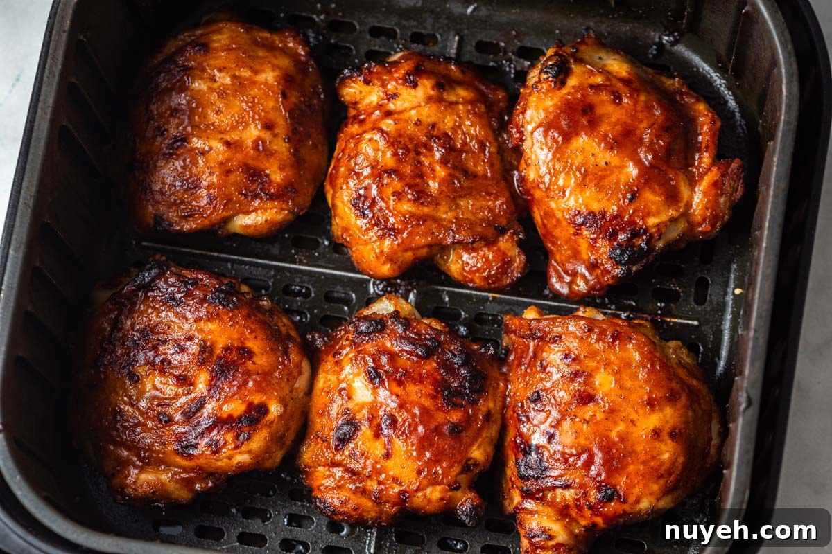 air fryer bbq chicken thighs in the air fryer basket.