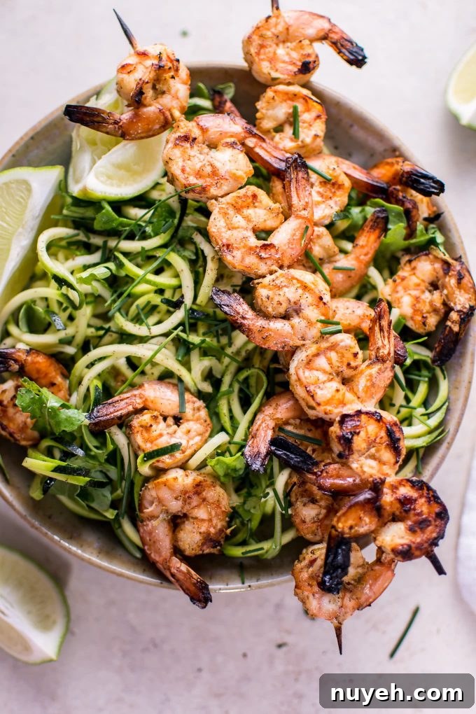 bowl with grilled chili lime shrimp zoodles and lime wedges