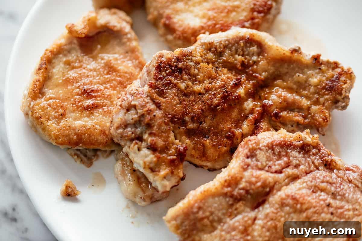 image of Breaded, seared bone-less pork chops on a white plate.