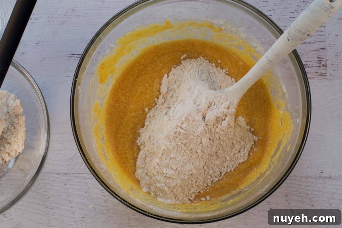Dry ingredients added to batter alternately with water in large glass bowl.