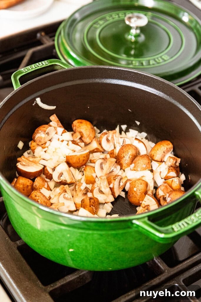 Creamy Chicken and Wild Rice Soup Recipe 5 Mushrooms and onion sauté in a pot.