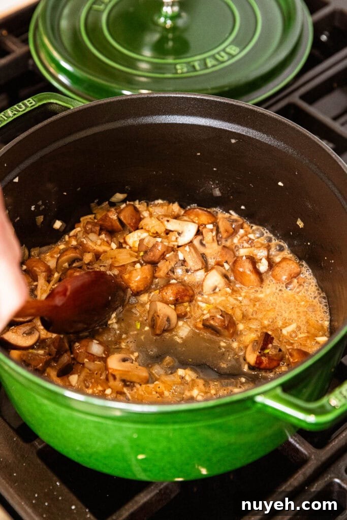 Creamy Chicken and Wild Rice Soup Recipe 6 Mushrooms and onion cook with butter and white wine.