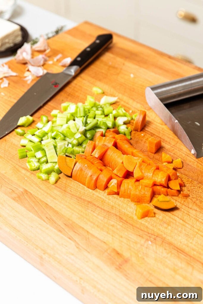 Creamy Chicken and Wild Rice Soup Recipe 7 Chopped celery and carrot on a cutting board.