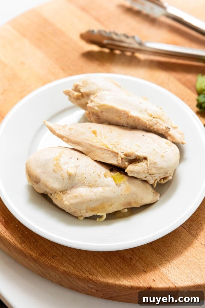 Creamy Chicken and Wild Rice Soup Recipe 9 Chicken breast on a plate after being poached.