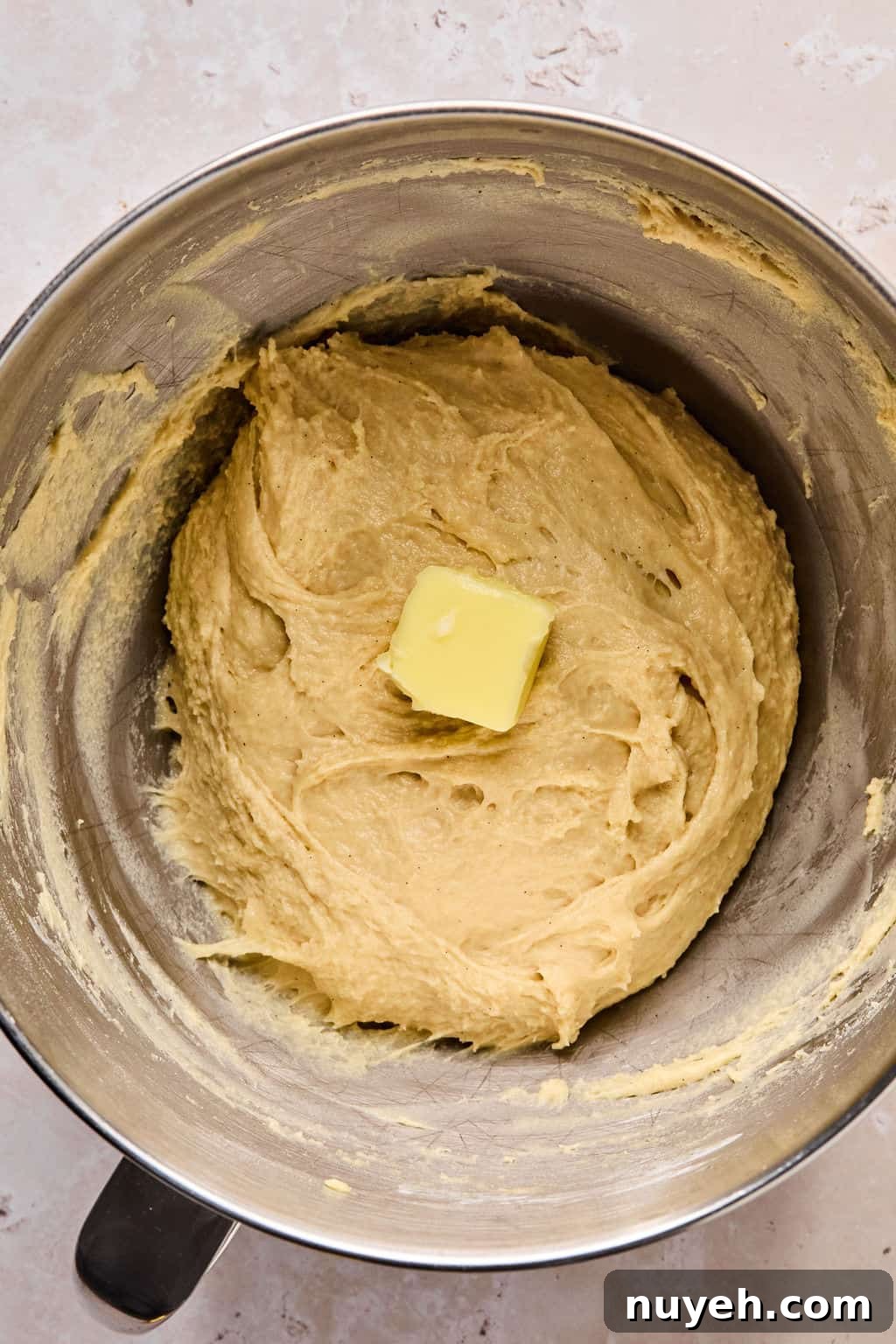 adding butter to cinnamon roll dough.
