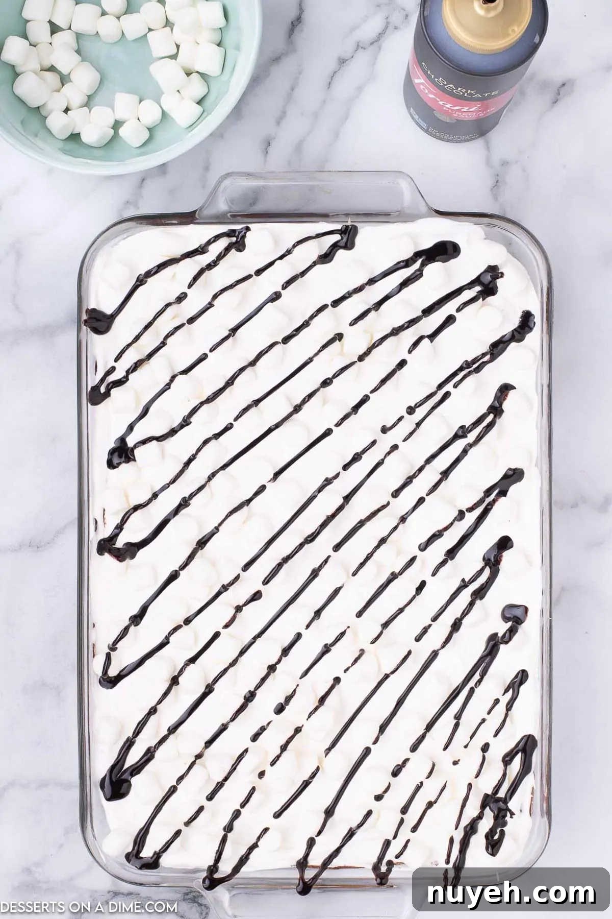 Whipped cream and chocolate drizzled over dish.