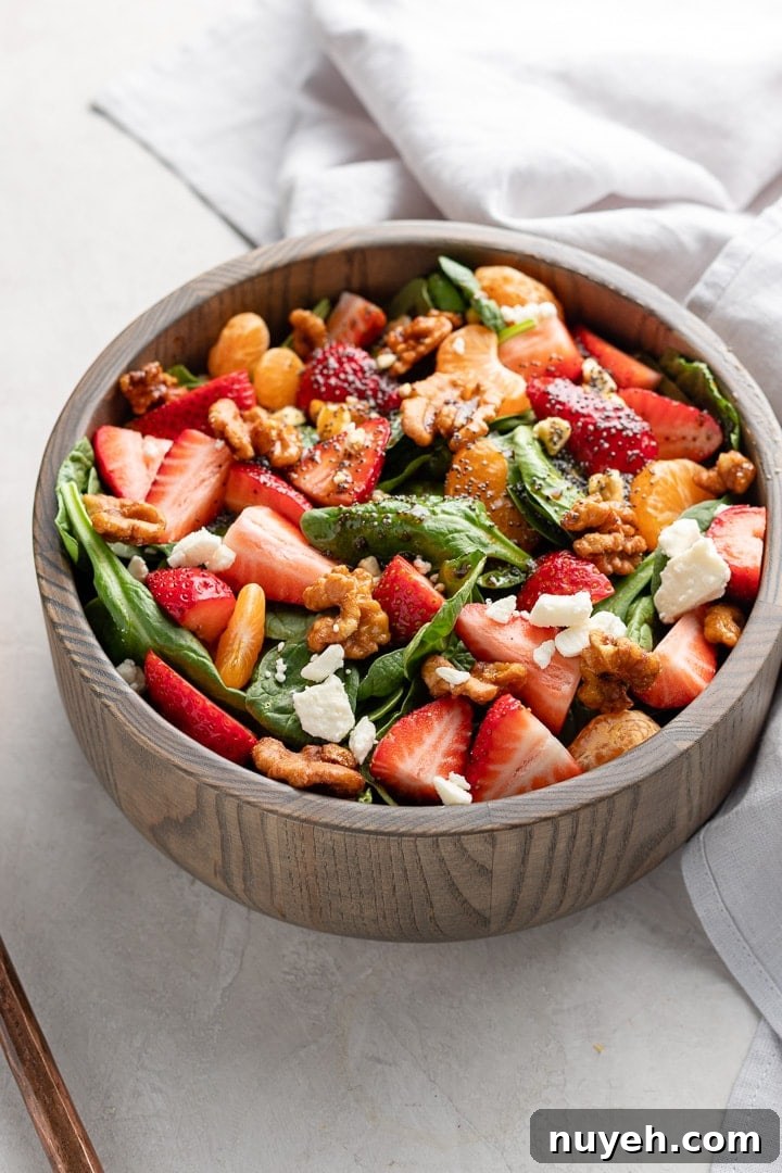 Close up of strawberry spinach salad in a bowl, ready to toss and serve.