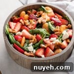 Close up of strawberry spinach salad in a bowl, ready to toss and serve.