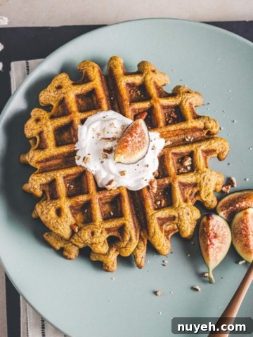 Pecan pumpkin waffles on a green serving plate.