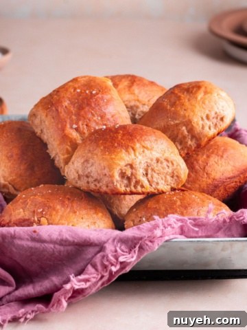 Banana yeast bread roll served on a pan with kitchen towel, and a bowl of butter.