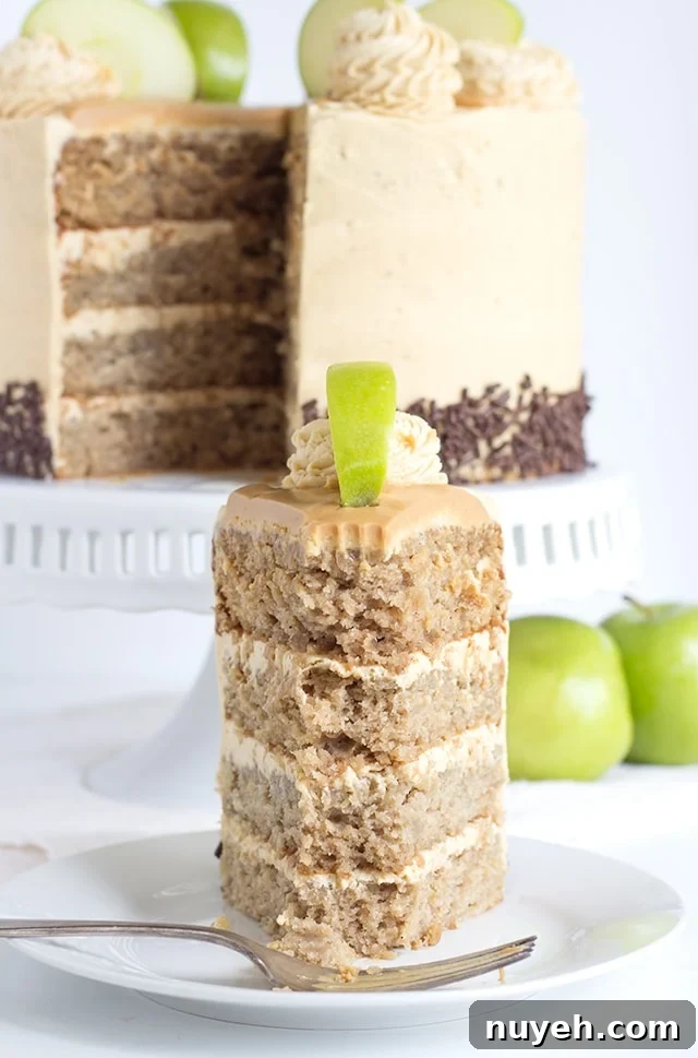 a slice of 4 layer apple cake filled and topped with peanut butter frosting