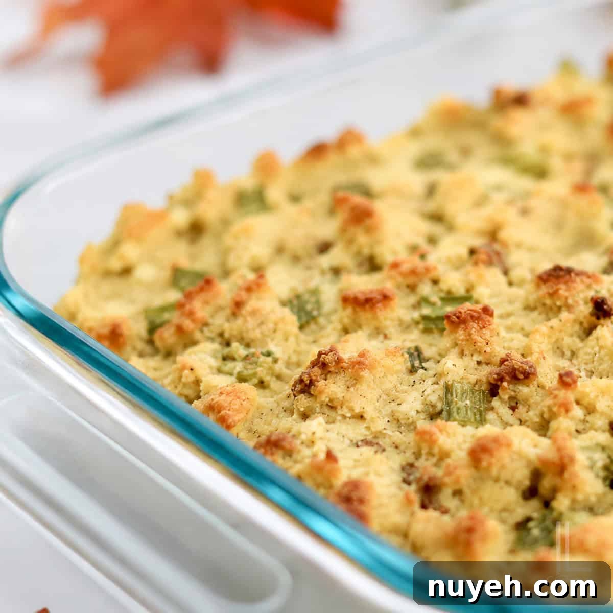 Close-up of homemade Jiffy cornbread dressing with sausage in a glass baking dish.
