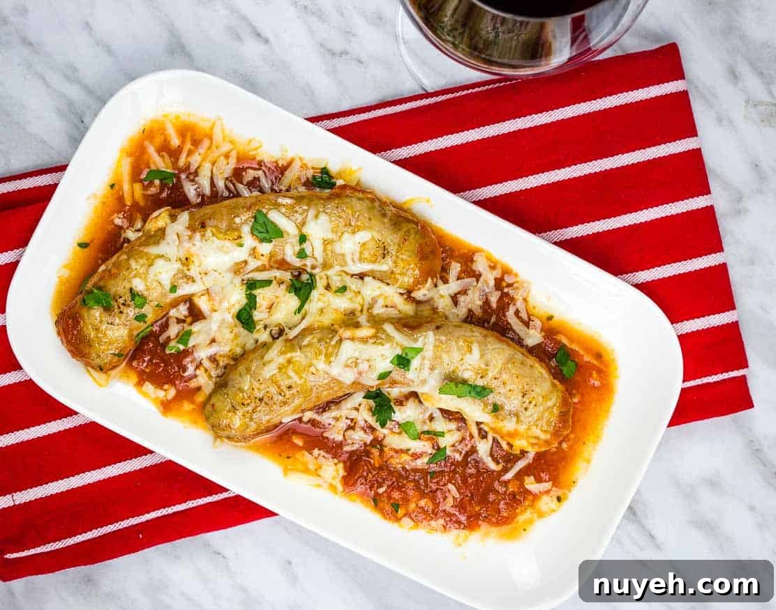 Sausage Parmigiana on a white plate with a red napkin and a glass of wine.