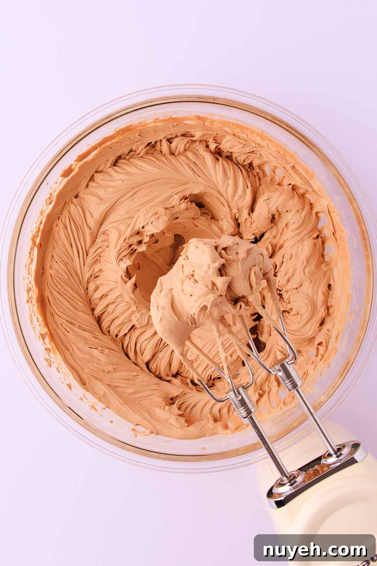 The whipped milk chocolate mousse, with a cream coloured kitchenaid electric hand mixer.