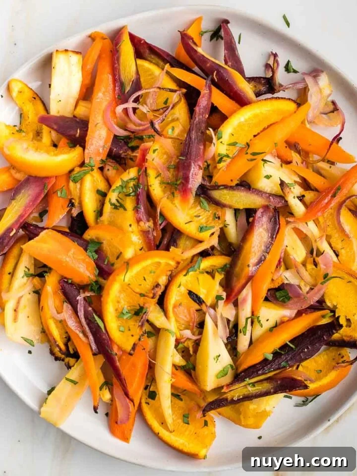 Plate filled with colorful roasted carrots and parsnips with oranges.