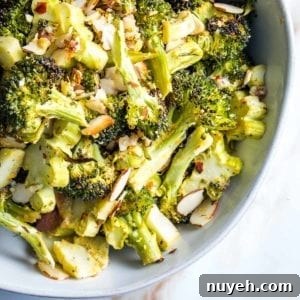 close up of a bowl of roasted broccoli with sliced almonds