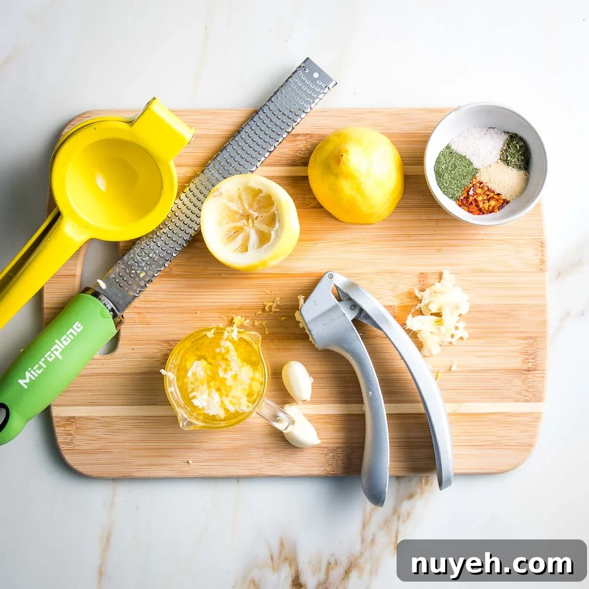 Juicing lemons, pressing garlic and mixing spices.