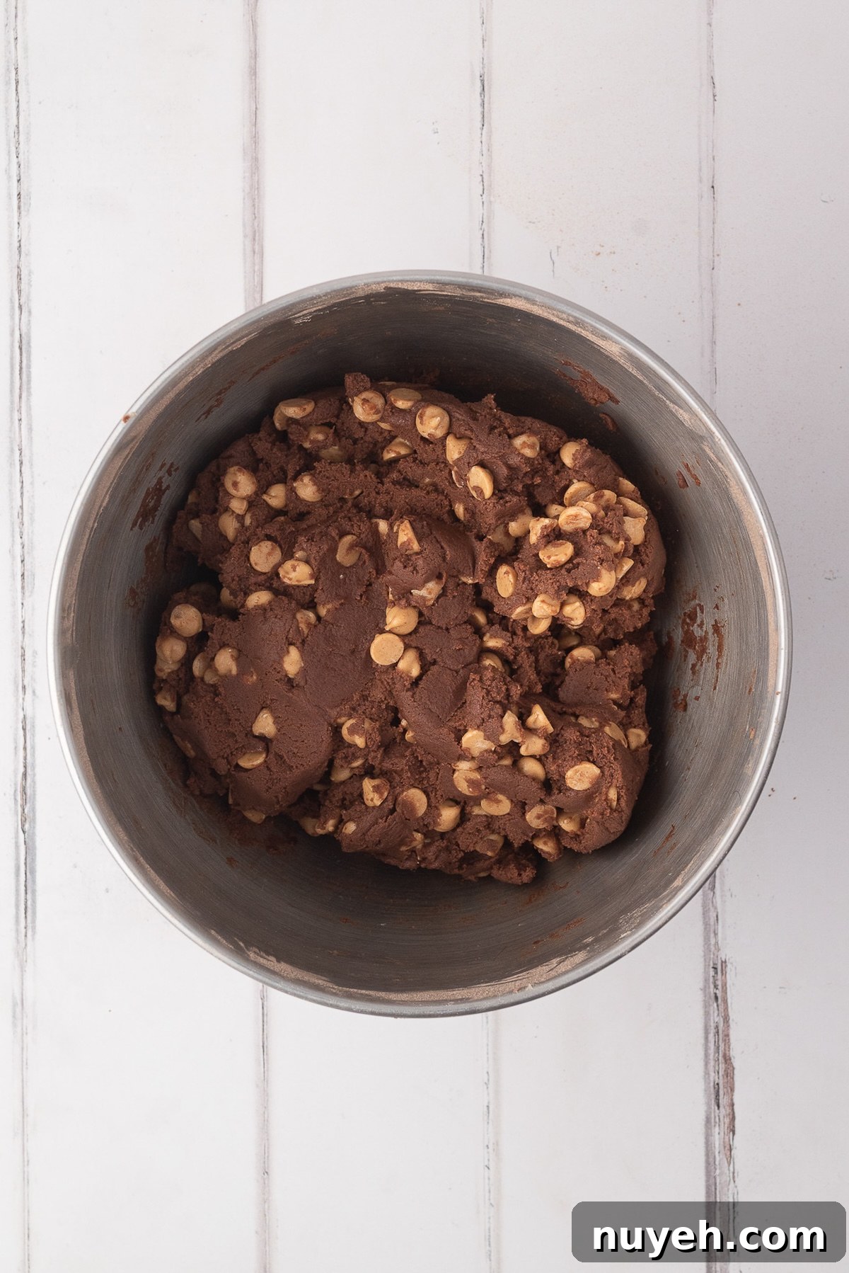 Folding in the Reese's peanut butter chips into this thick cocoa cookie dough.