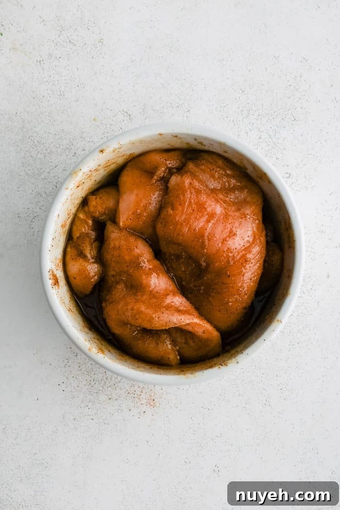 Four chicken cutlets in a medium bowl seasoned all over with olive oil, salt, black pepper, garlic powder, onion powder, and paprika.