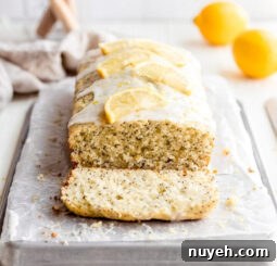 lemon poppyseed bread on parchment paper and baking sheet. end cut off showing inside of loaf.