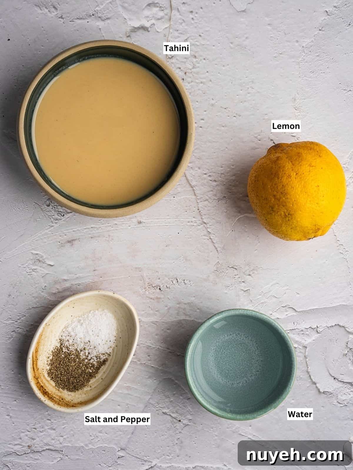 Tahini sauce recipe ingredients with individual labels on a board.