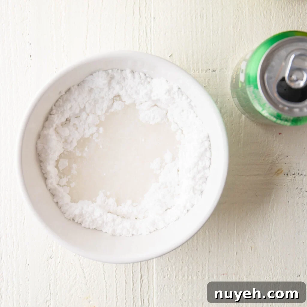 7-up soda and confectioners sugar in a small white mixing bowl