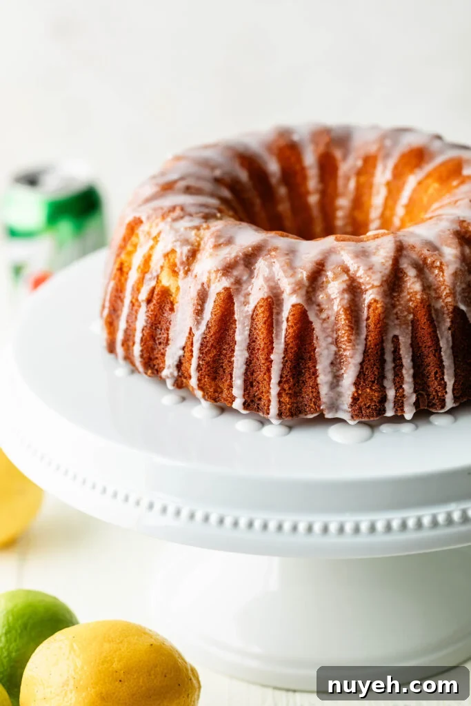 7-up pound cake on white cake stand with lemons and limes