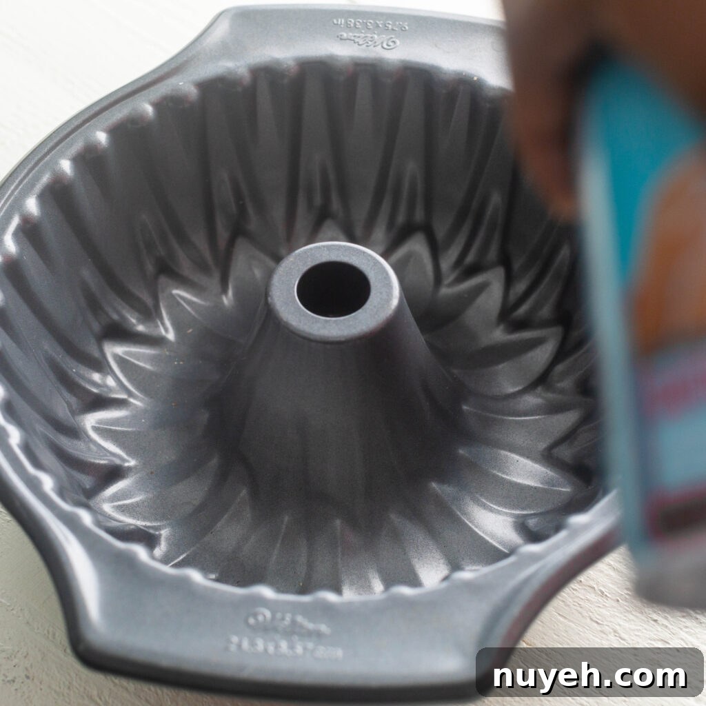 spraying bundt pan with non stick cooking spray