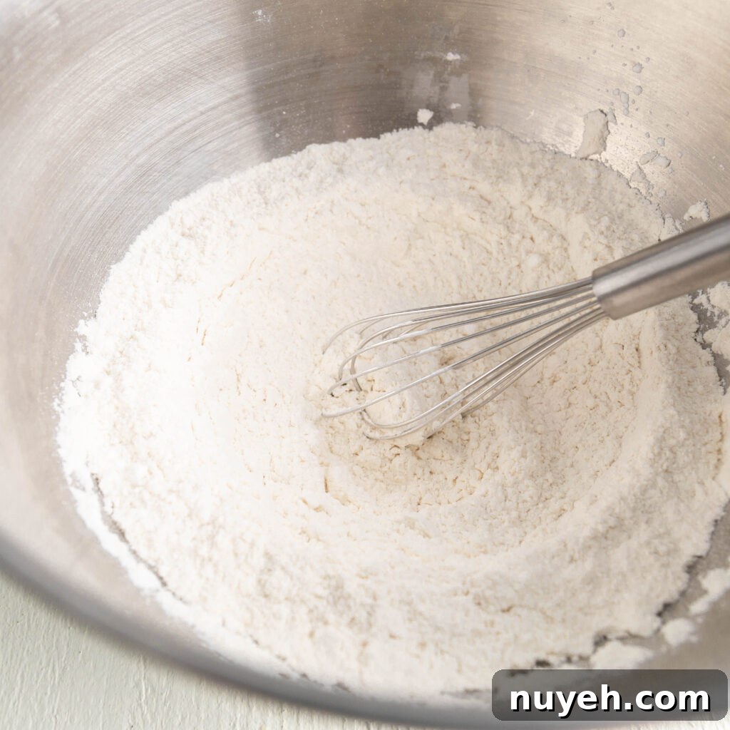 whisking flour, cornstarch, salt, baking powder, and baking soda in a large bowl