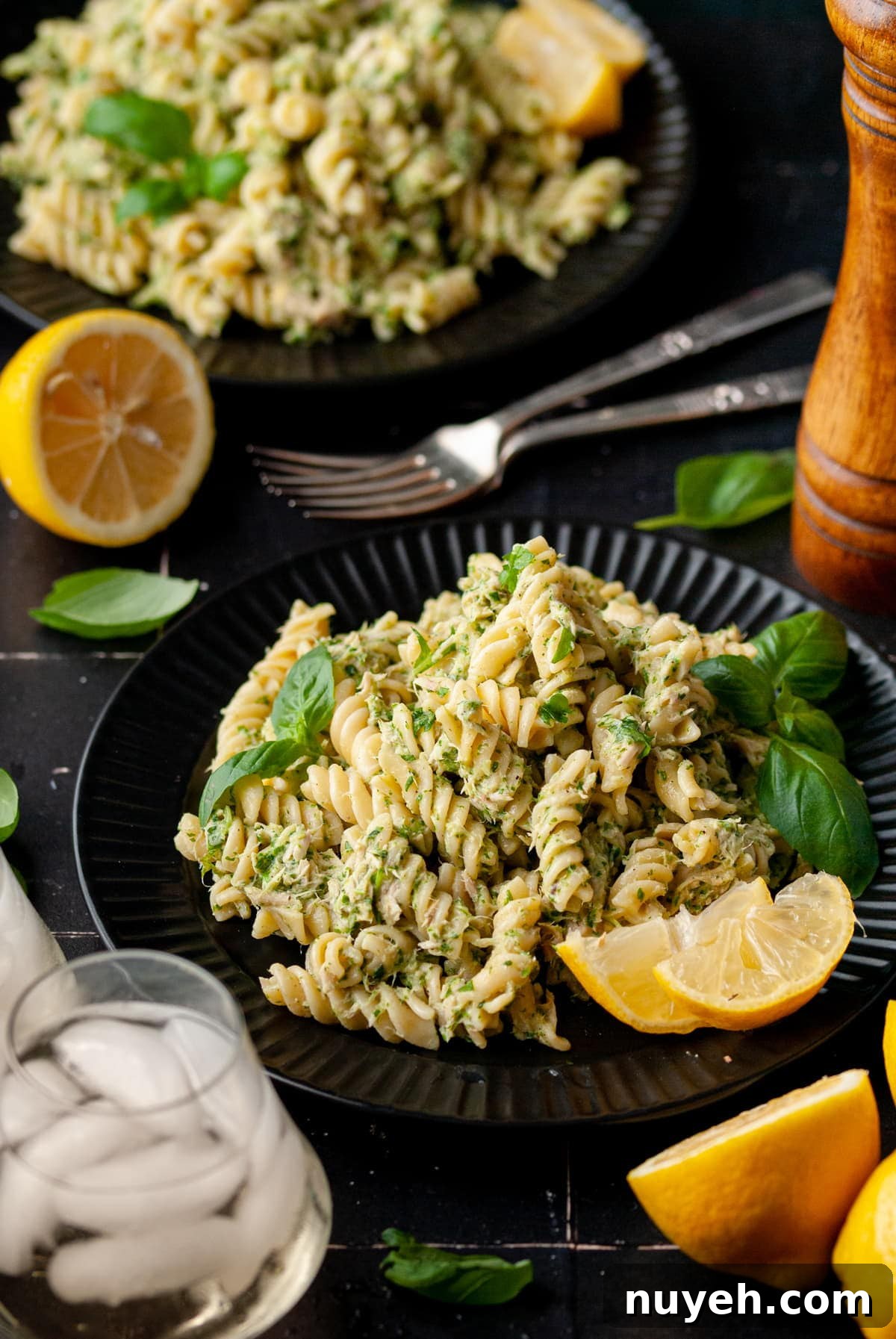 4-Ingredient Canned Tuna and Pesto Pasta Salad 2 2 plates with tuna pesto pasta salad, two forks, and a salt and pepper shaker.