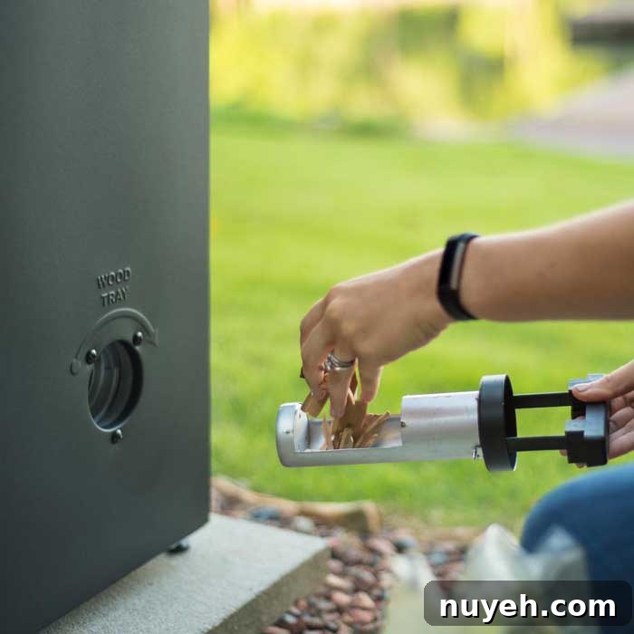 inserting wood chips into tube on electric smoker