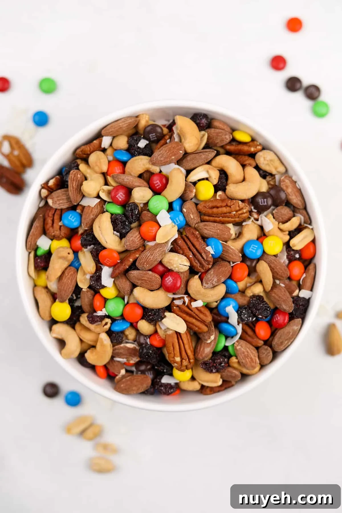 A large bowl of trail mix on a white surface.