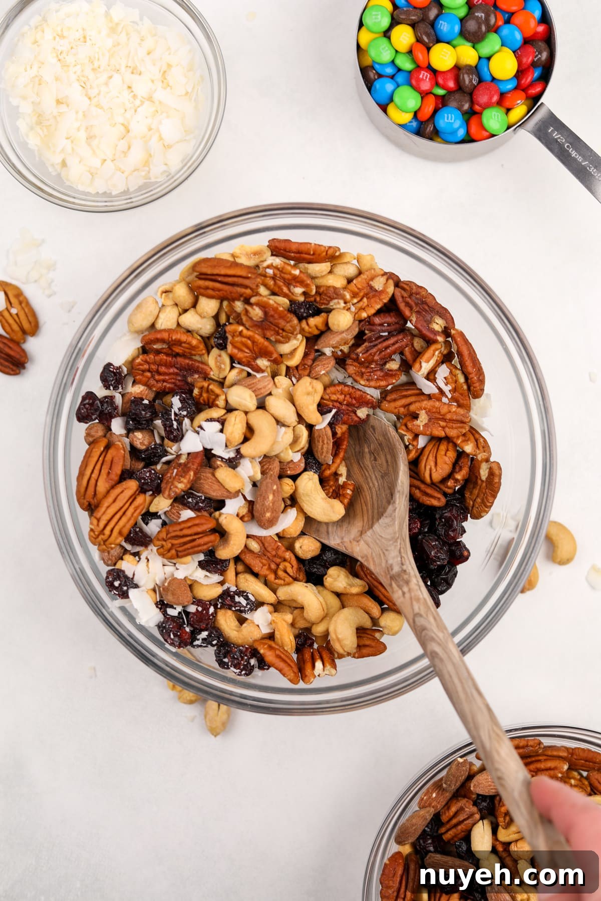 A large bowl filled with mixed nuts, dried fruit, and coconut.