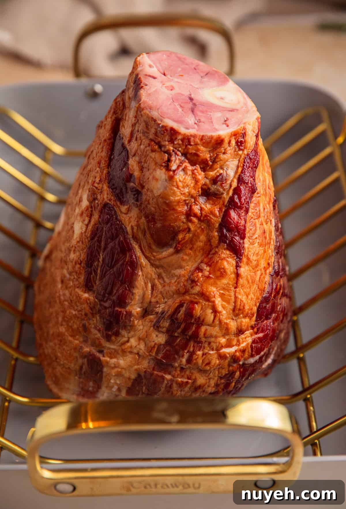 Spiral cut ham on roasting rack in roasting pan.